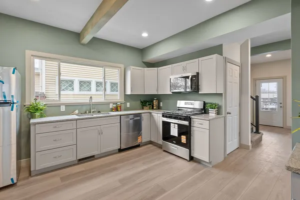 a kitchen with granite countertop a stove top oven sink and cabinets