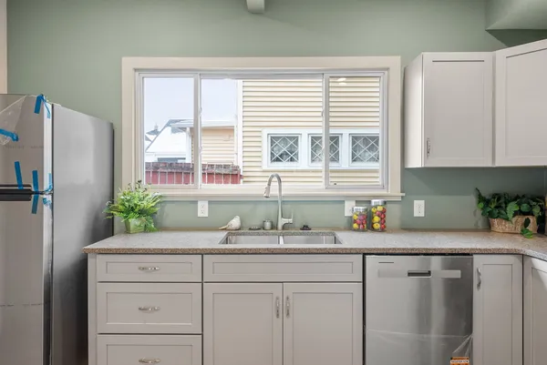 a kitchen with stainless steel appliances white cabinets and a window