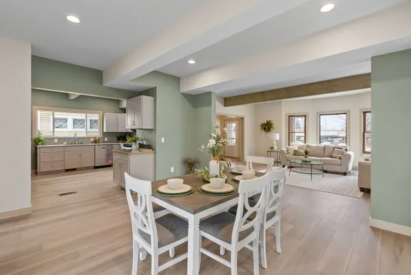 a view of a dining room and livingroom with furniture wooden floor and a view of kitchen