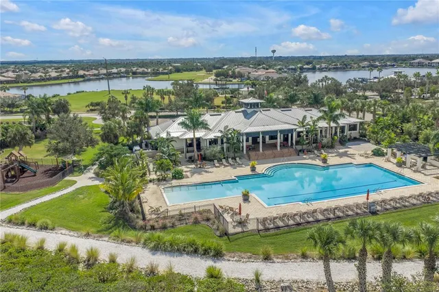 a room with kitchen island a sink a stove a refrigerator and white cabinets