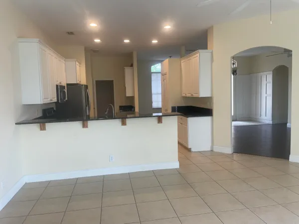 a view of a kitchen with a large window and refrigerator