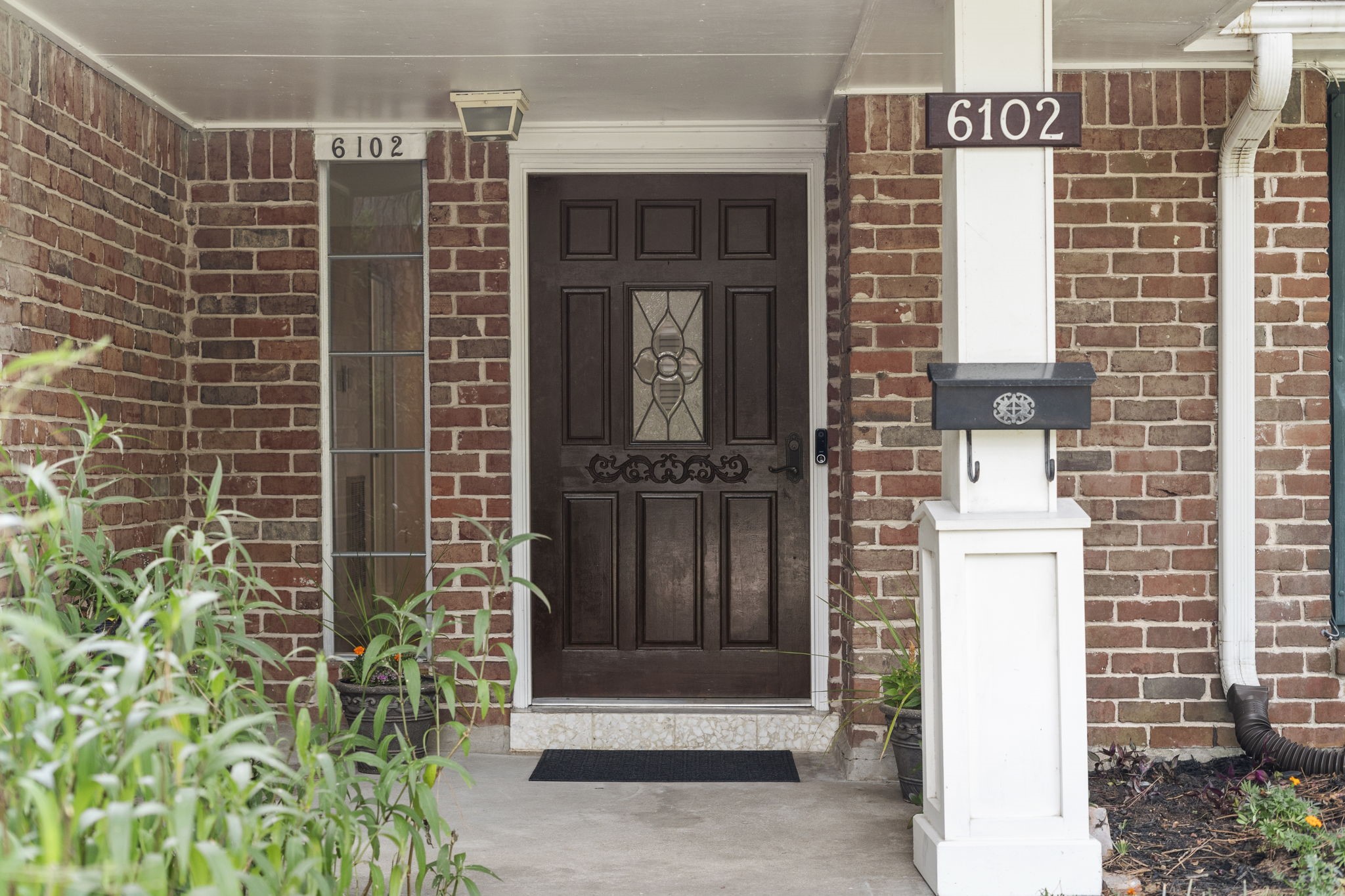 6102 Redding Road Houston, TX 77036 - Photo 5 of 40 A charming covered front porch welcomes you to the home, highlighted by a gorgeous custom solid-wood front door with beautiful leaded glass details.