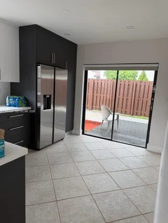 a kitchen with kitchen island granite countertop a refrigerator a stove and a sink