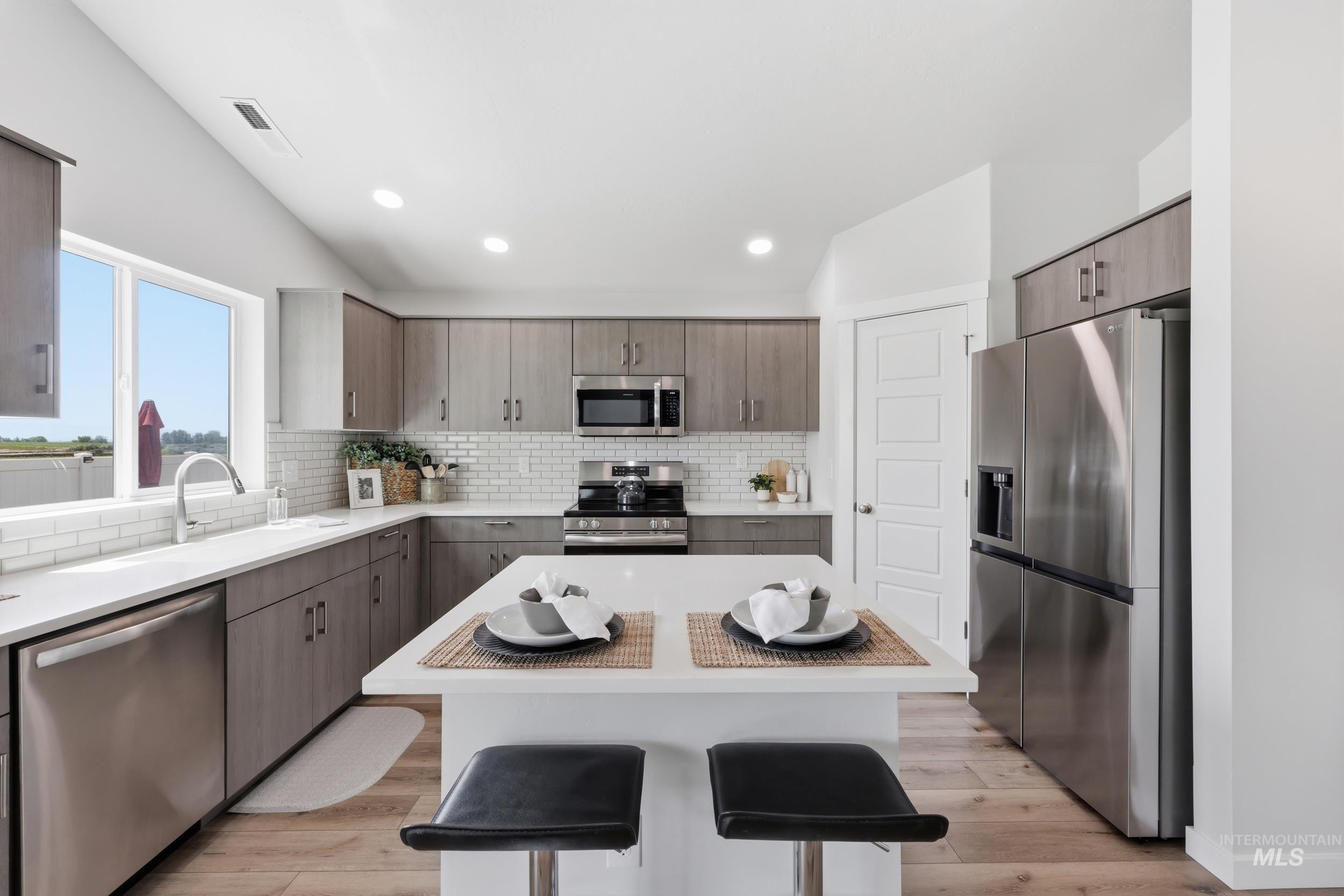 3665 W Lane Meridian, ID 83642 - Photo 10 of 42 Open-concept living space featuring a vaulted ceiling with recessed lighting, a modern ceiling fan, and multiple windows for natural light