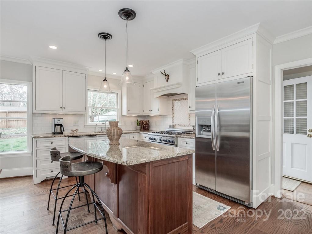 416 Whitestone Road Charlotte, NC 28270 - Photo 11 of 28 a kitchen with stainless steel appliances granite countertop a refrigerator a sink a stove and white cabinets with wooden floor