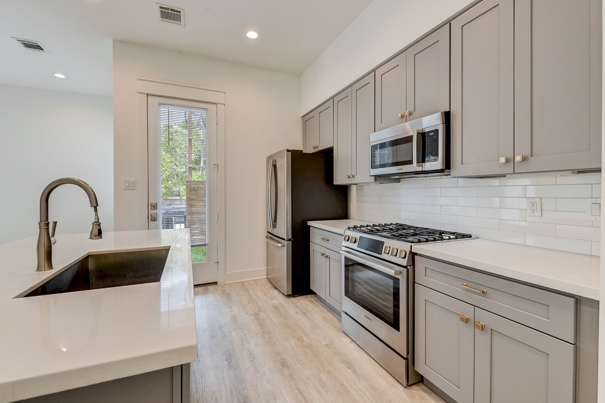 2575 Judiway Street Houston, TX 77018 - Photo 37 of 48 a kitchen with white cabinets stainless steel appliances and a sink