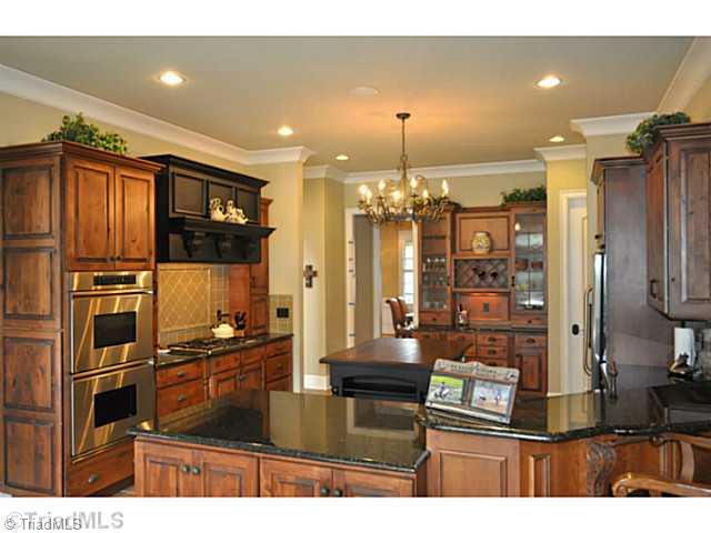 7045 Denison Road Summerfield, NC 27358 - Photo 4 of 16 Kitchen. This gourmet kitchen enjoys bespoke cabinets, granite counter tops, Dacor and Bosch appliances as well as a big pantry and center island.