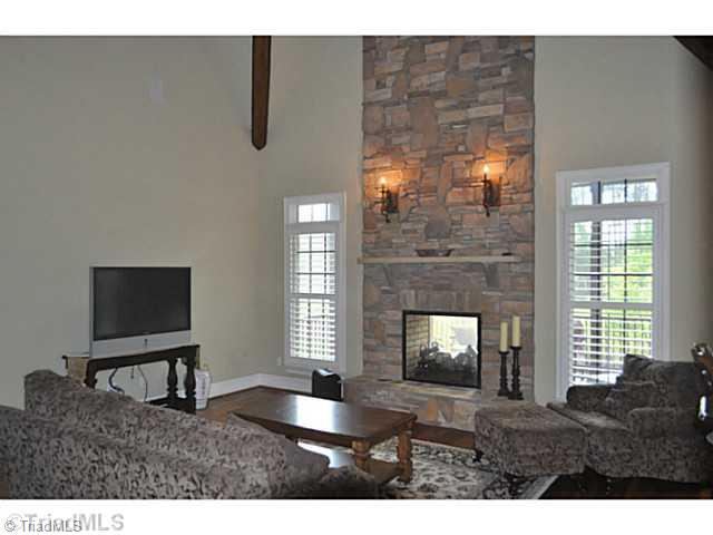 7045 Denison Road Summerfield, NC 27358 - Photo 6 of 16 Den/Family/Great Room. This comfortable large den enjoys a two story stone see through fireplace, and a vaulted ceiling. The home s back staircase is found here as well.