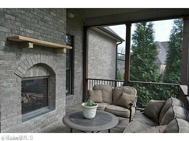 7045 Denison Road Summerfield, NC 27358 - Photo 7 of 16 Screened Porch. The charming screened porch shares the den s see through fireplace.