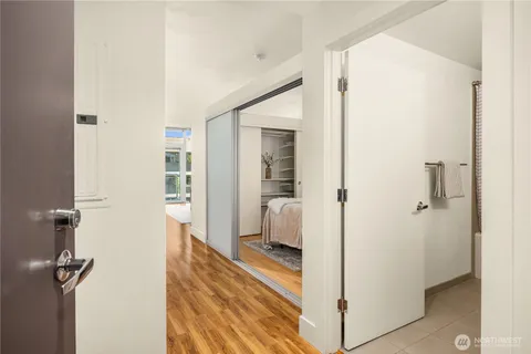 a view of a hallway with bathroom and wooden floor