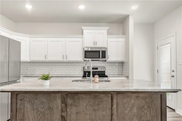 a kitchen with a sink a microwave and cabinets