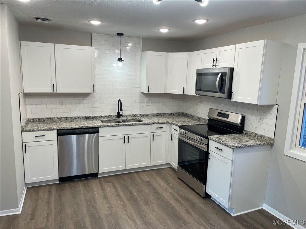 7617 Strath Road Henrico, VA 23231 - Photo 14 of 25 a kitchen with granite countertop white cabinets and white appliances
