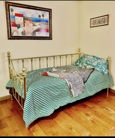 a bedroom with a bed and a painting on the wall