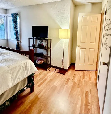 a bedroom with a bed and a flat screen tv