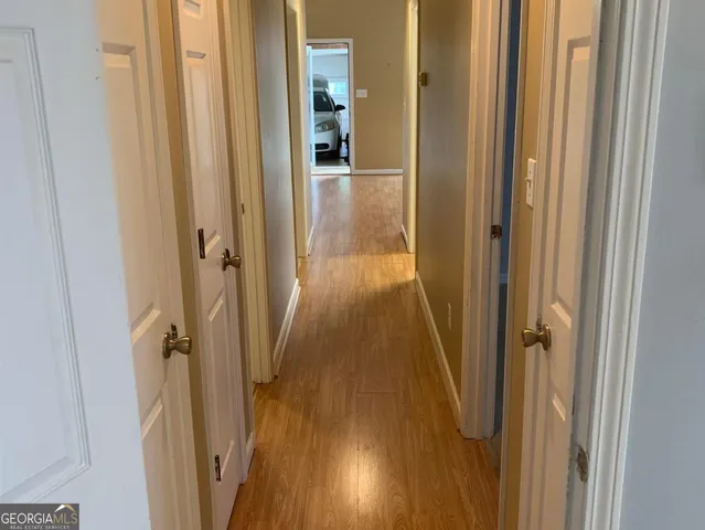 a view of a hallway with wooden floor and staircase