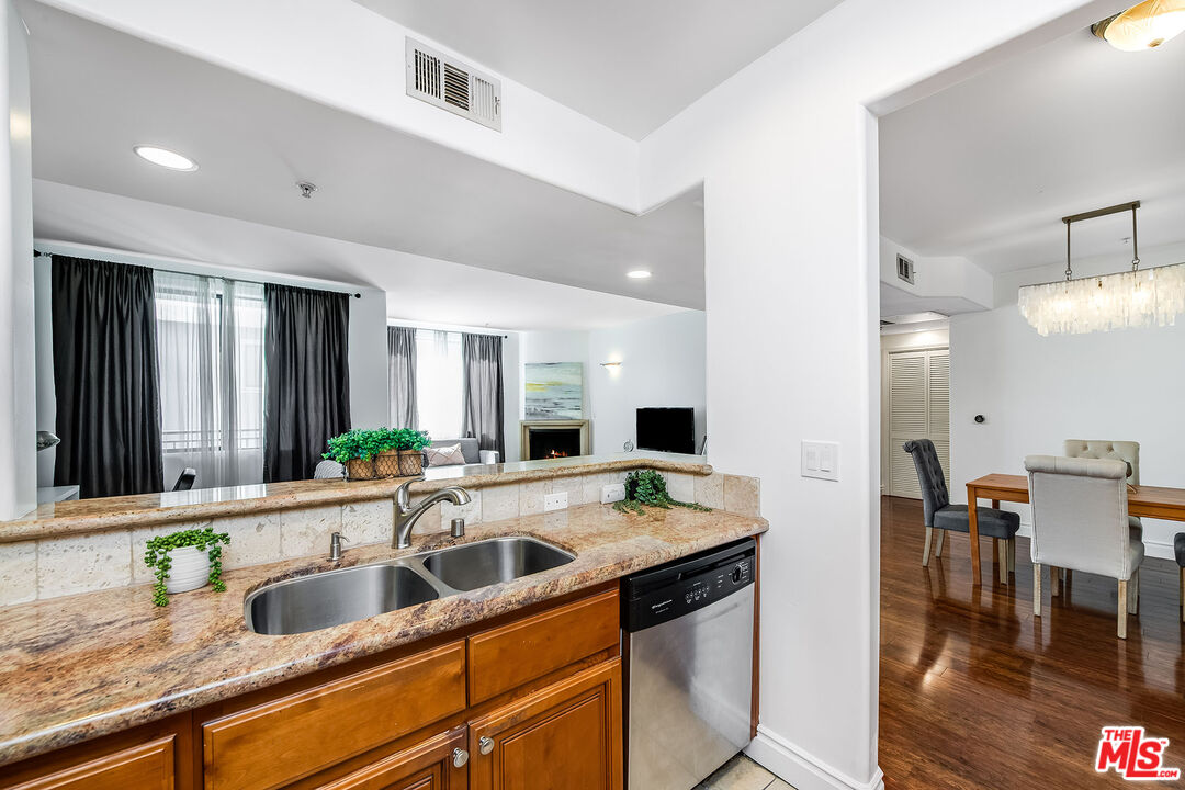 4724 Kester Avenue, Unit 209 Sherman Oaks, CA 91403 - Photo 12 of 27 a kitchen with granite countertop a sink and a refrigerator