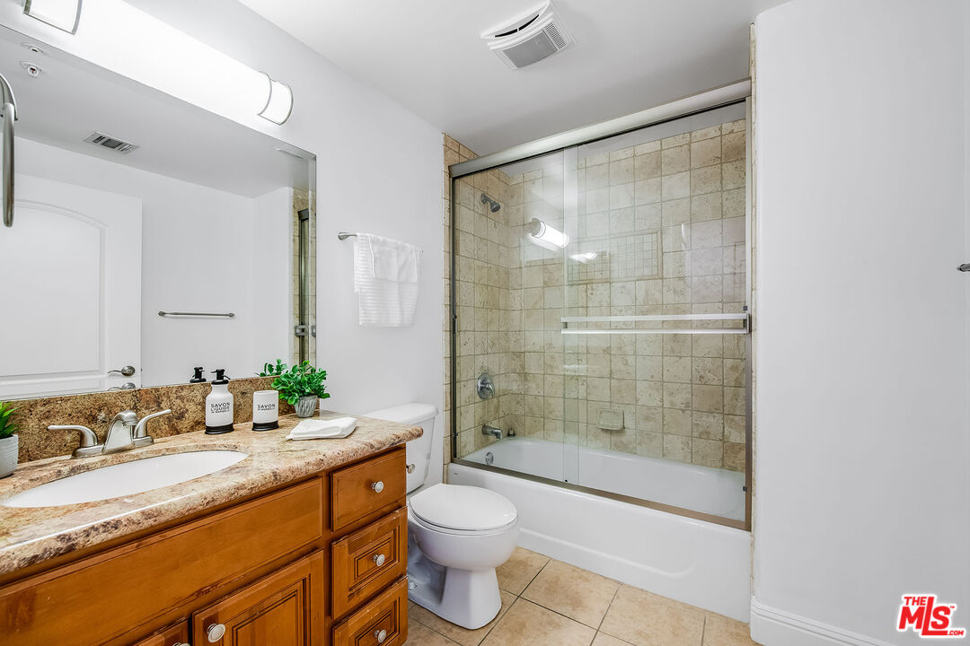4724 Kester Avenue, Unit 209 Sherman Oaks, CA 91403 - Photo 20 of 27 a bathroom with a granite countertop sink toilet and shower