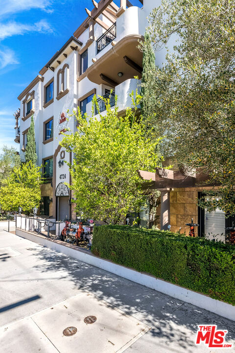 4724 Kester Avenue, Unit 209 Sherman Oaks, CA 91403 - Photo 27 of 27 a front view of a building with an outdoor space and seating