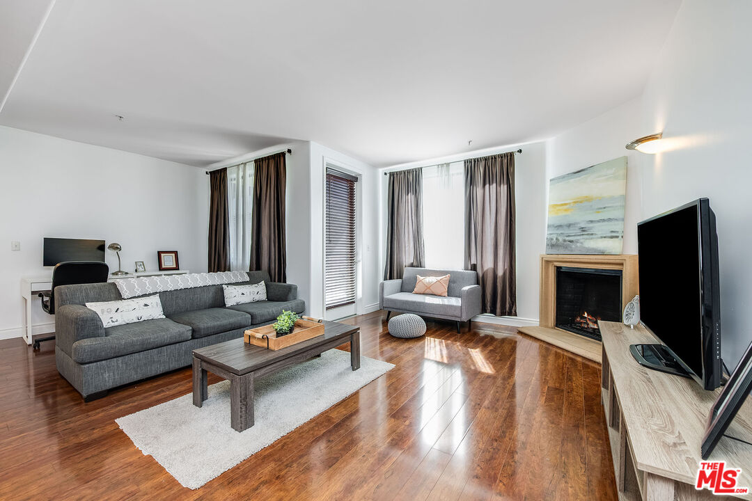 4724 Kester Avenue, Unit 209 Sherman Oaks, CA 91403 - Photo 3 of 27 a living room with fireplace furniture and a flat screen tv