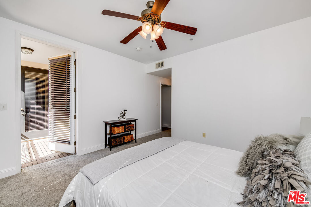 4724 Kester Avenue, Unit 209 Sherman Oaks, CA 91403 - Photo 5 of 27 a bedroom with a bed and a chandelier