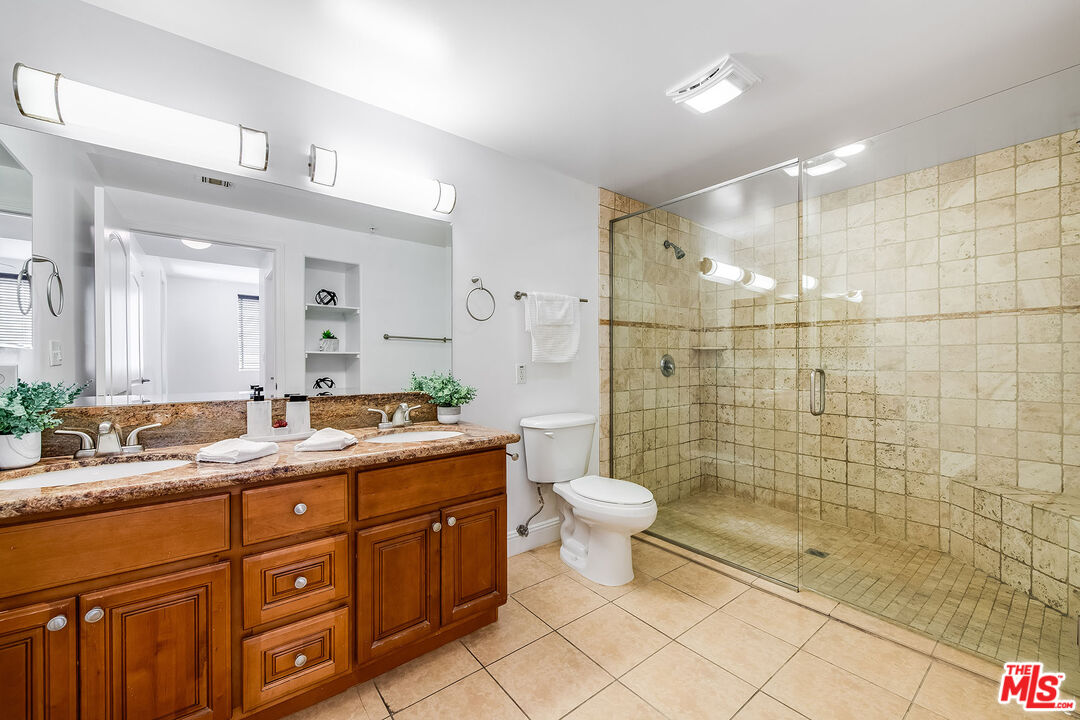4724 Kester Avenue, Unit 209 Sherman Oaks, CA 91403 - Photo 6 of 27 a spacious bathroom with a granite countertop sink a toilet a mirror and shower