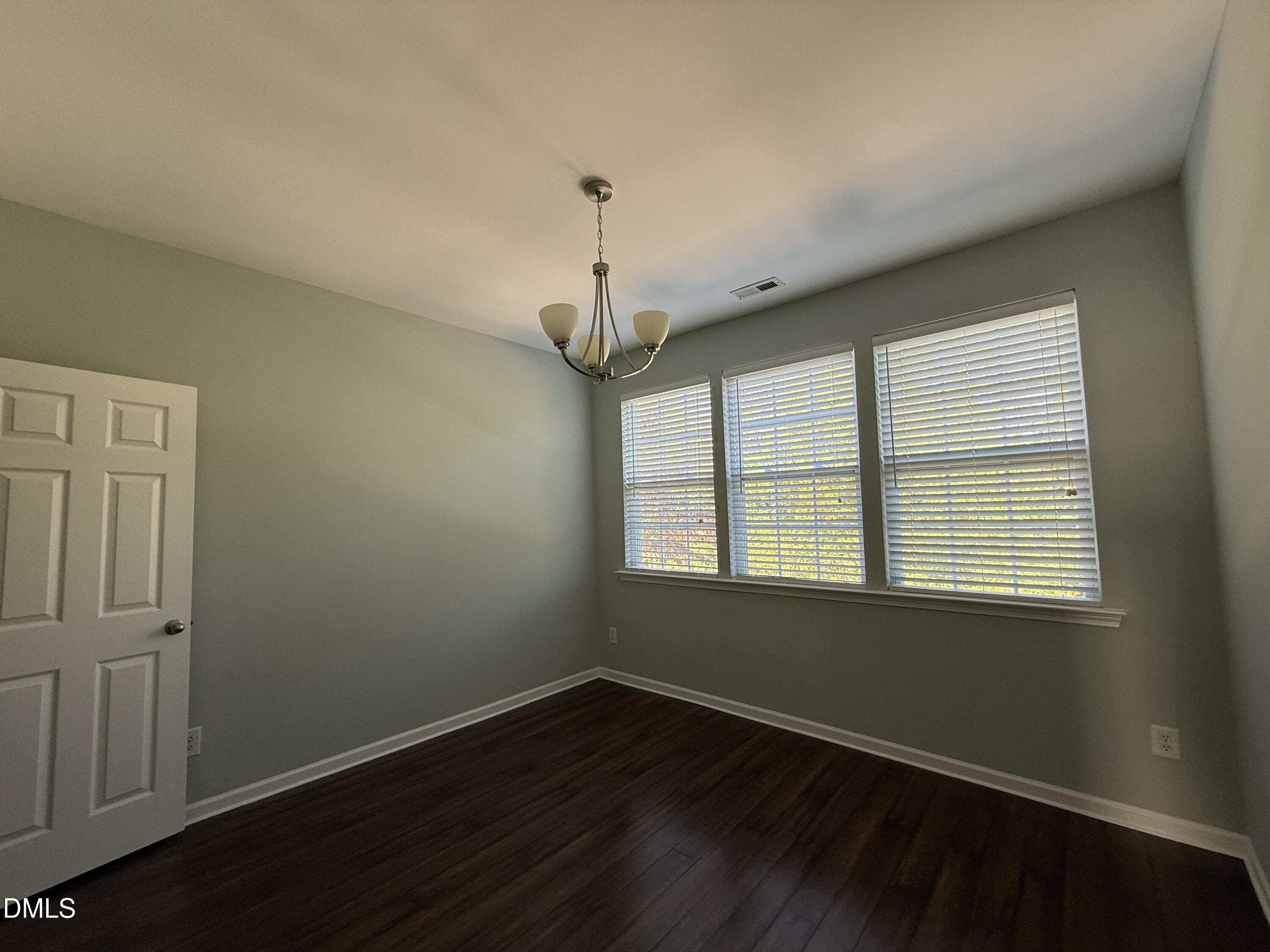 606 Sawcut Lane Apex, NC 27502 - Photo 14 of 30 a view of an empty room with wooden floor and a window