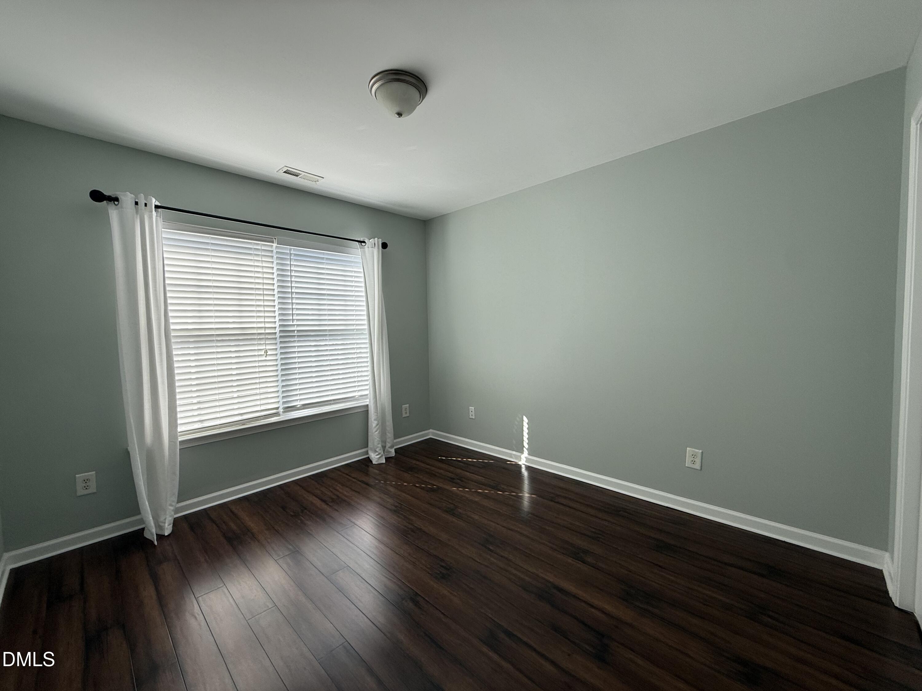 606 Sawcut Lane Apex, NC 27502 - Photo 22 of 30 an empty room with wooden floor and windows