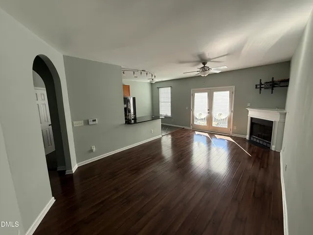 an empty room with wooden floor and a fireplace