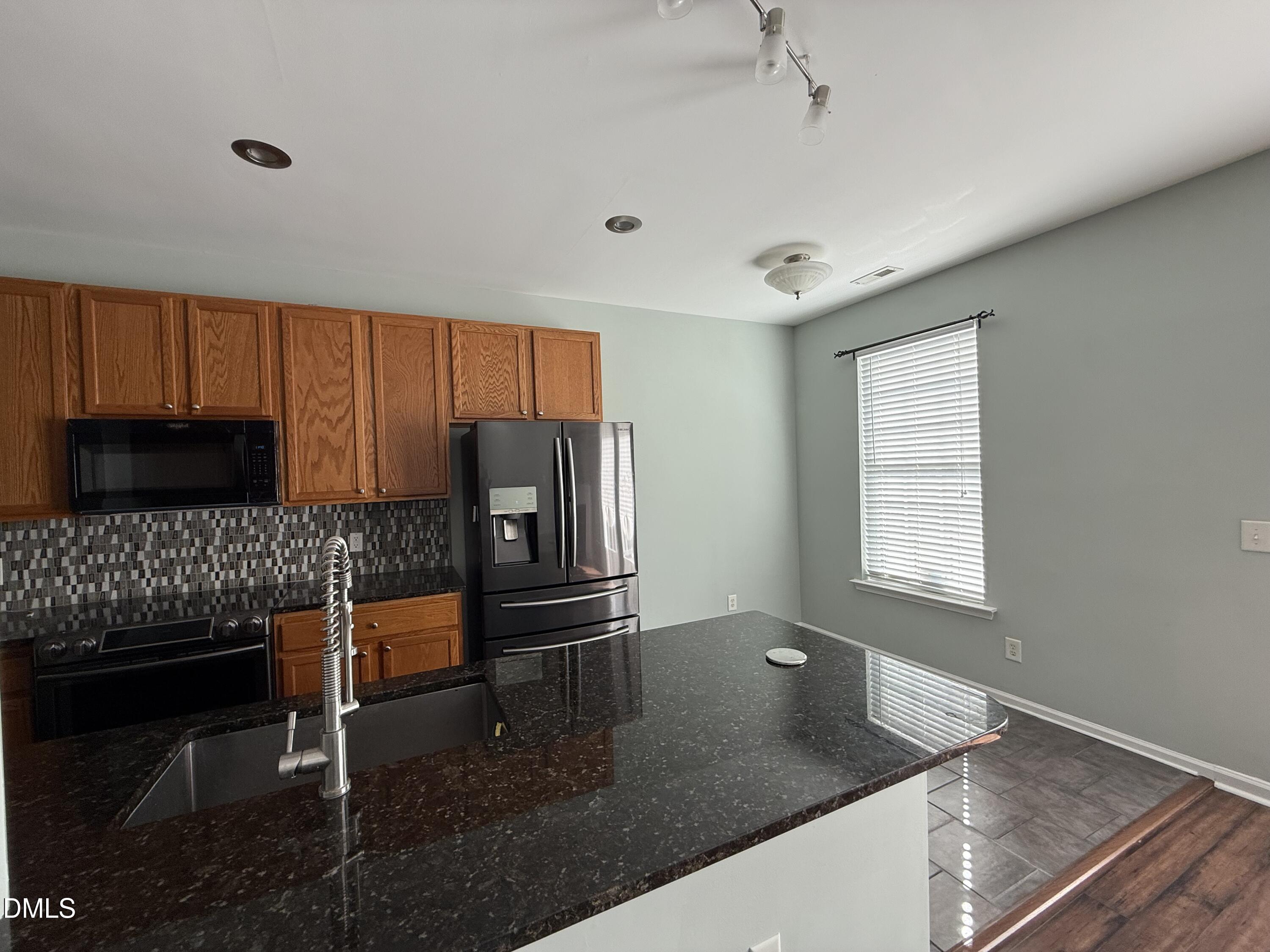 606 Sawcut Lane Apex, NC 27502 - Photo 7 of 30 a kitchen with granite countertop a refrigerator a stove a microwave and island