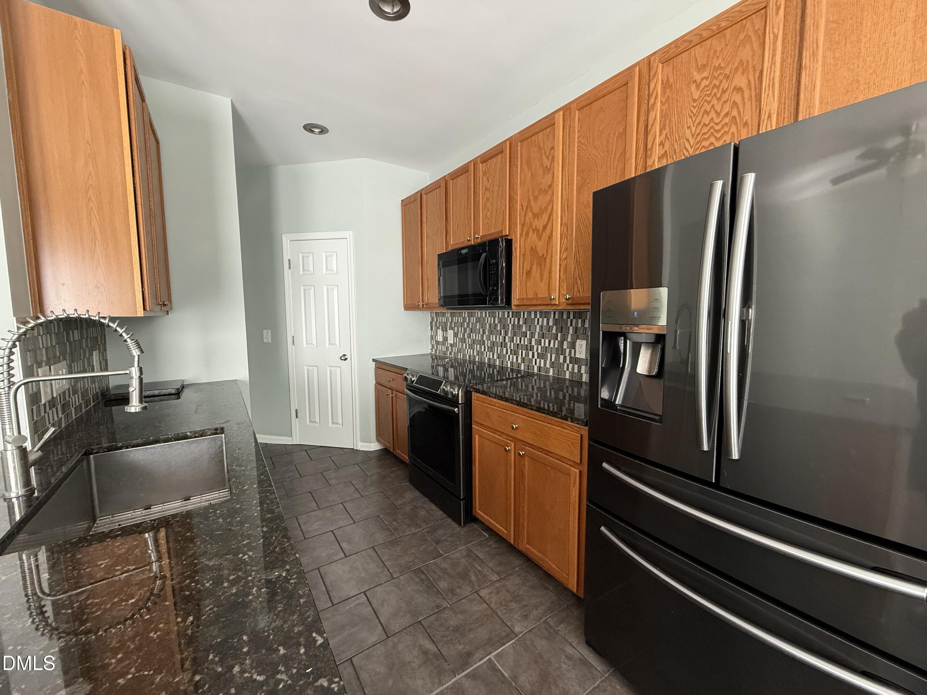 606 Sawcut Lane Apex, NC 27502 - Photo 8 of 30 a kitchen with stainless steel appliances granite countertop a refrigerator stove and sink