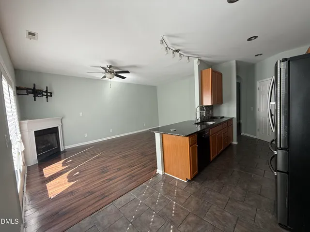 a kitchen with stainless steel appliances granite countertop a refrigerator a stove and a sink with wooden floor