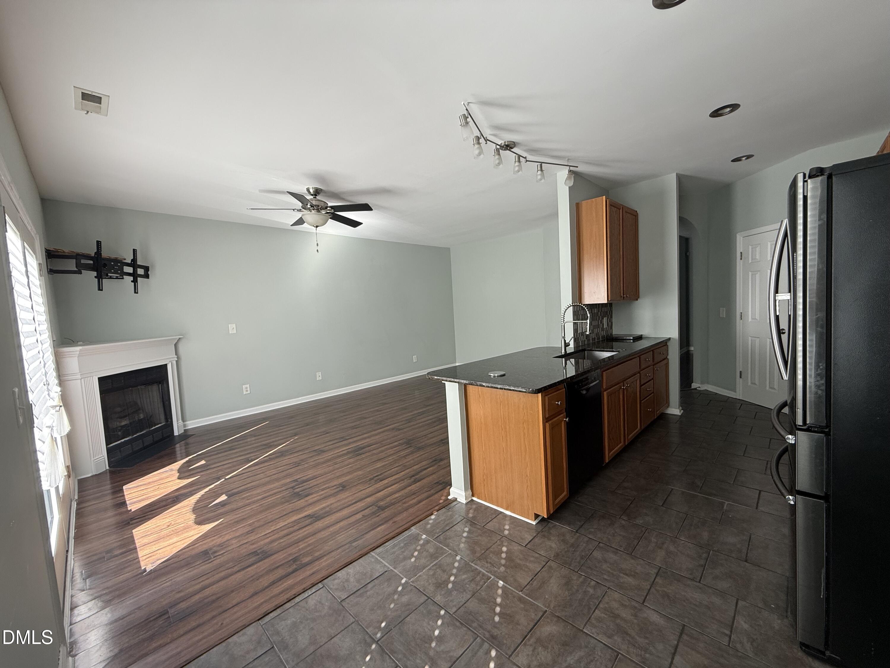 606 Sawcut Lane Apex, NC 27502 - Photo 9 of 30 a kitchen with stainless steel appliances granite countertop a refrigerator a stove and a sink with wooden floor