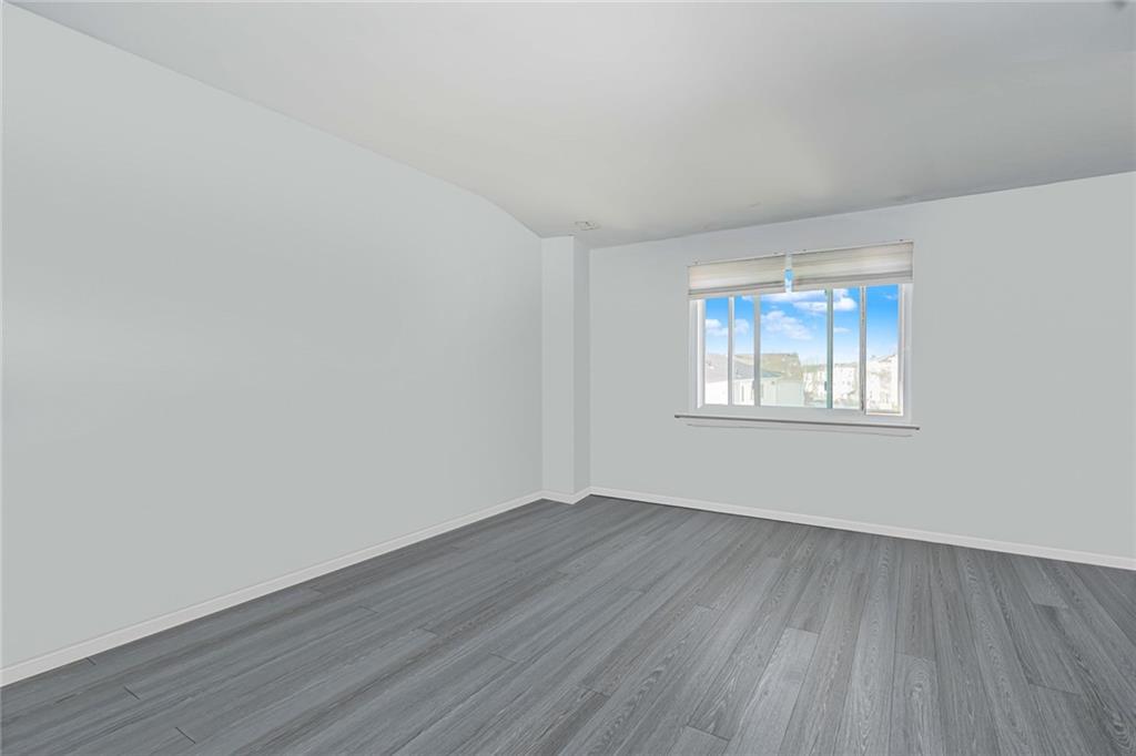 206 Rosedale Avenue Staten Island, NY 10312 - Photo 9 of 19 an empty room with wooden floor and windows