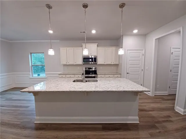 a view of kitchen with kitchen island a sink stainless steel appliances and cabinets