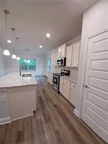 a kitchen with kitchen island granite countertop a sink cabinets and stainless steel appliances