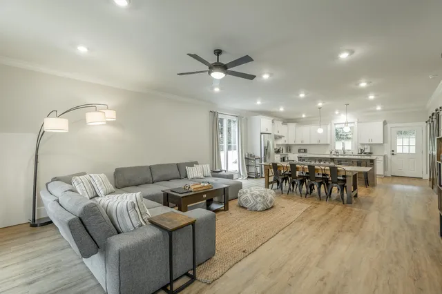 a living room with furniture and a view of kitchen