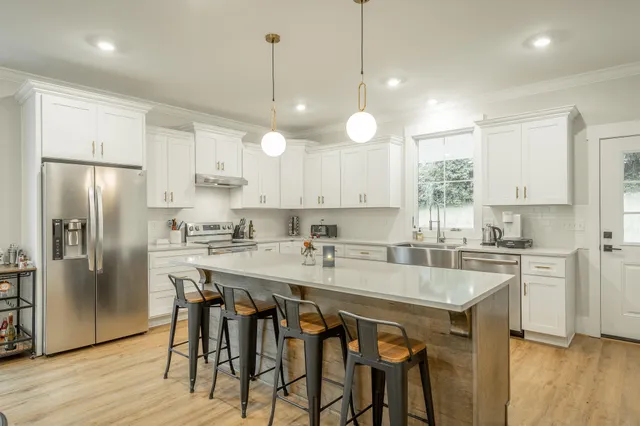 a kitchen with a table chairs sink and cabinets