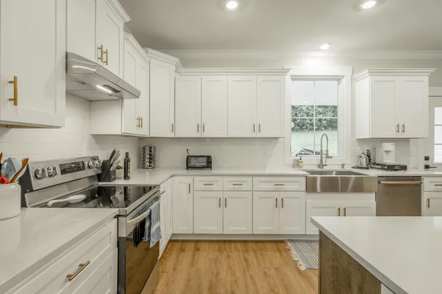 a kitchen with granite countertop white cabinets and white appliances