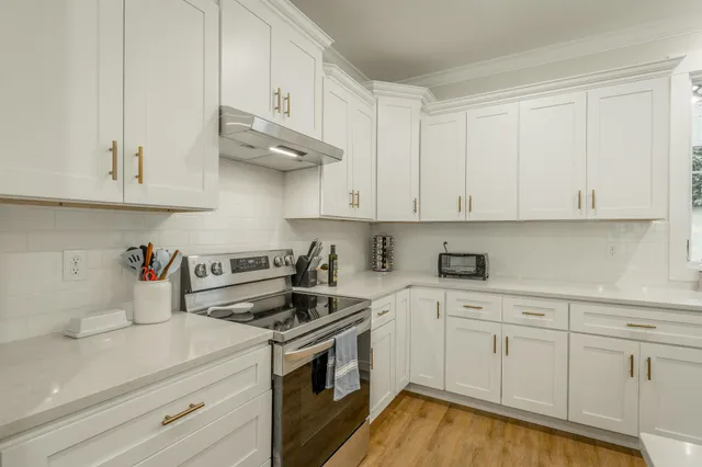 a kitchen with granite countertop a sink and white cabinets