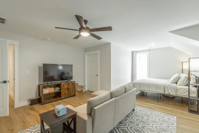a living room with furniture and a wooden floor