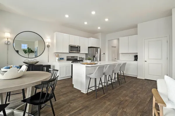 a kitchen with stainless steel appliances granite countertop a stove a sink dishwasher and a microwave with wooden floor
