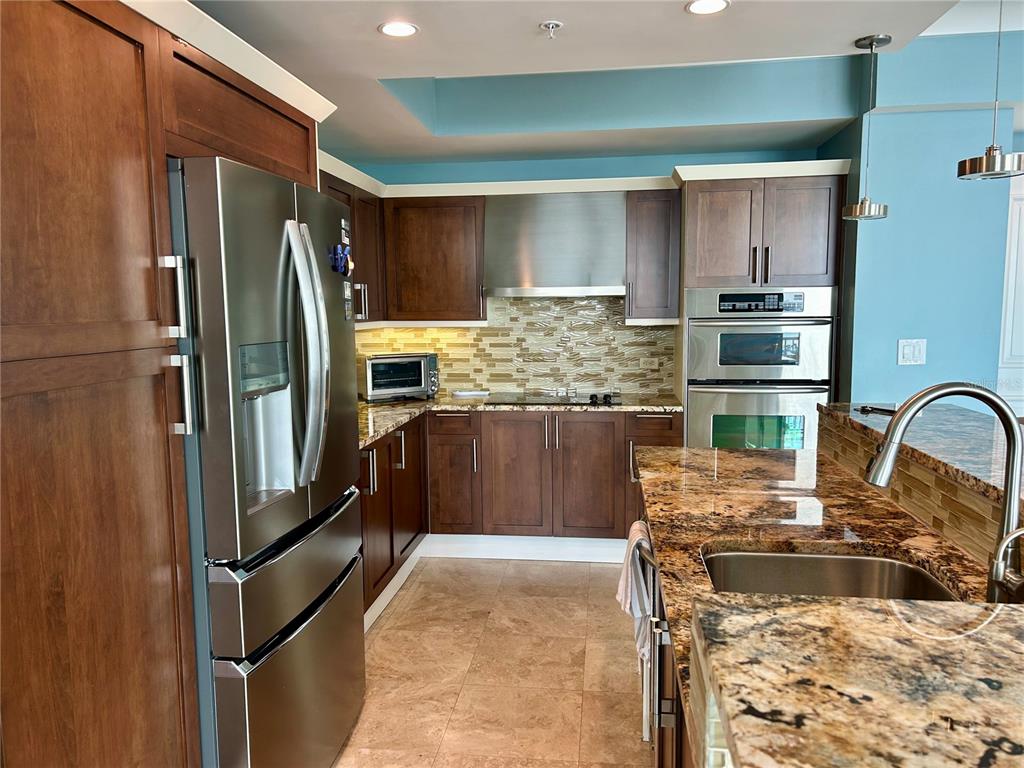 1350 Main Street, Unit 1210 Sarasota, FL 34236 - Photo 11 of 53 a kitchen with kitchen island a counter top space cabinets and stainless steel appliances