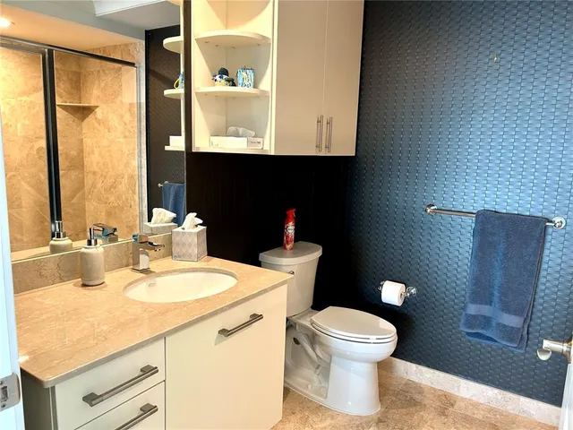 a bathroom with a toilet a sink and a mirror