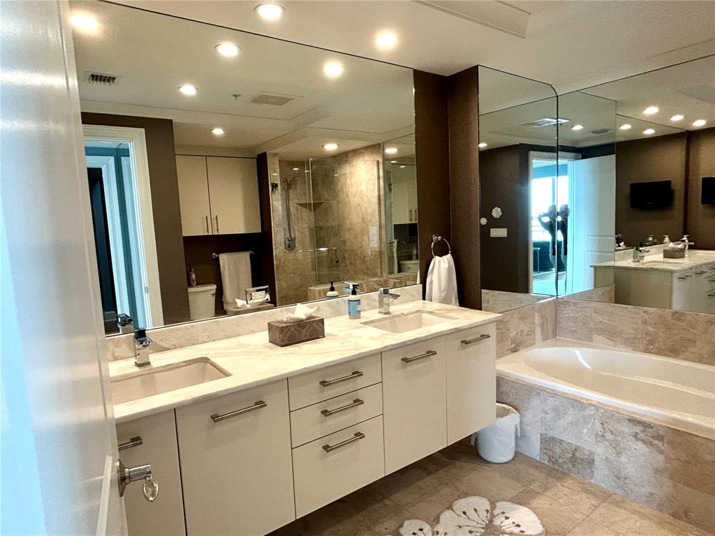 1350 Main Street, Unit 1210 Sarasota, FL 34236 - Photo 34 of 53 a spacious bathroom with a double vanity sink a large mirror and a bathtub