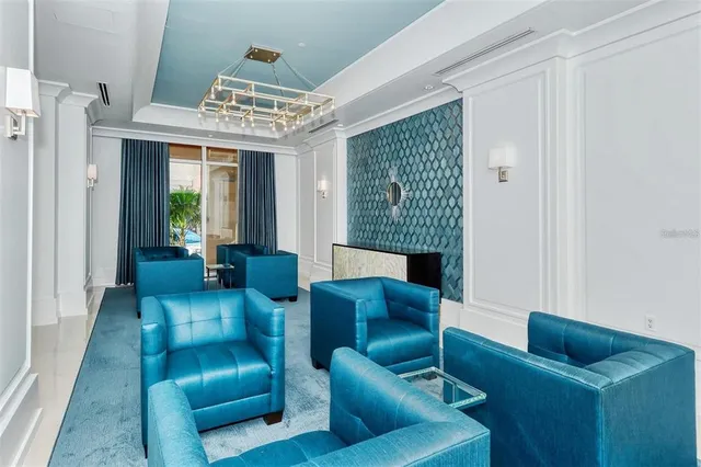 a living room with stainless steel appliances granite countertop a couch a dining table and chairs