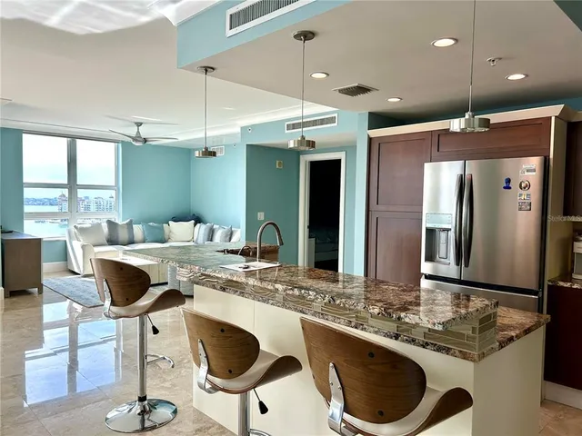 a kitchen with a dining table chairs sink and white cabinets
