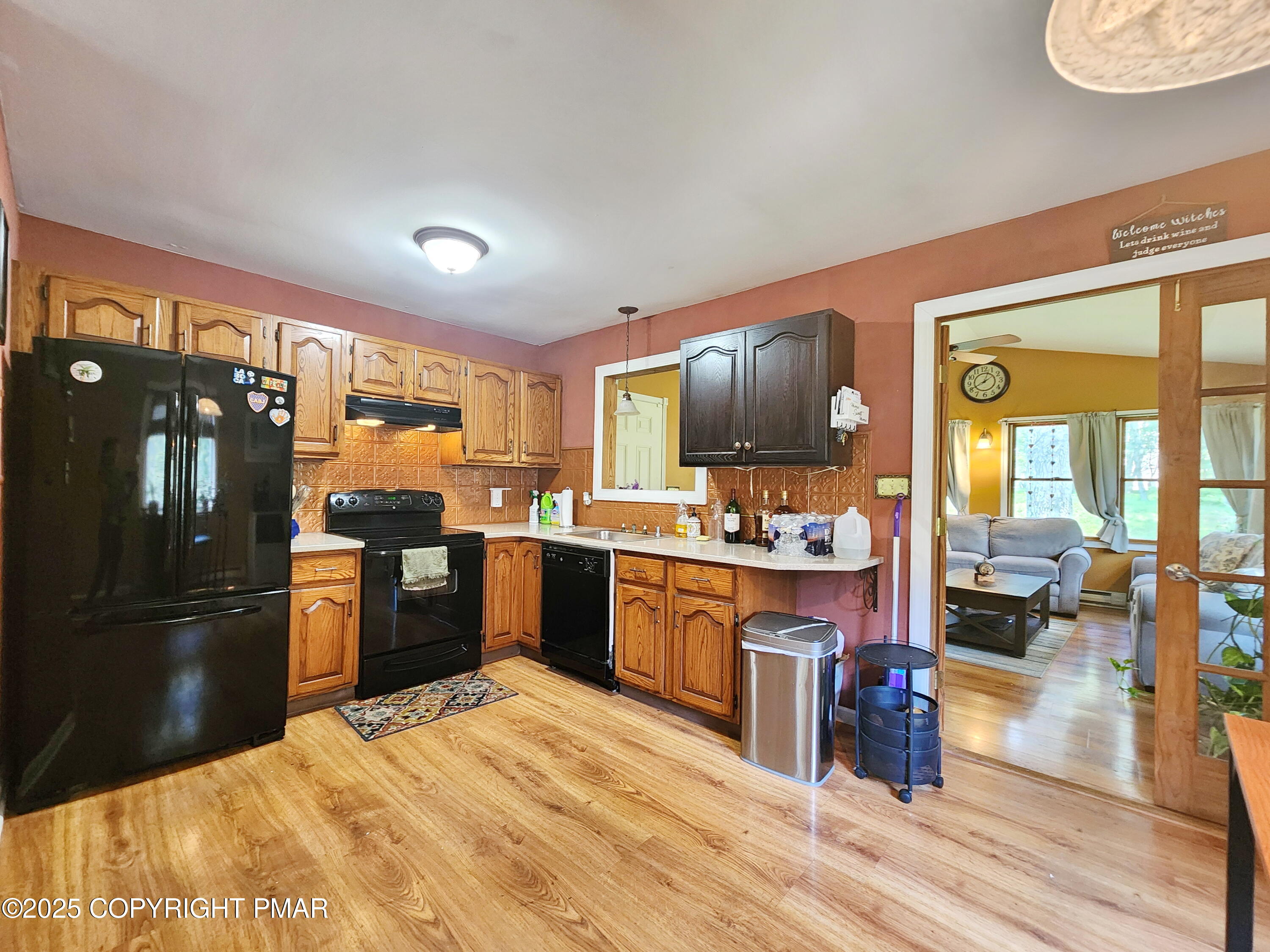 1152 Steele Circle Bushkill, PA 18324 - Photo 2 of 15 a kitchen with stainless steel appliances kitchen island granite countertop a refrigerator a sink dishwasher a stove with wooden cabinets and wooden floor