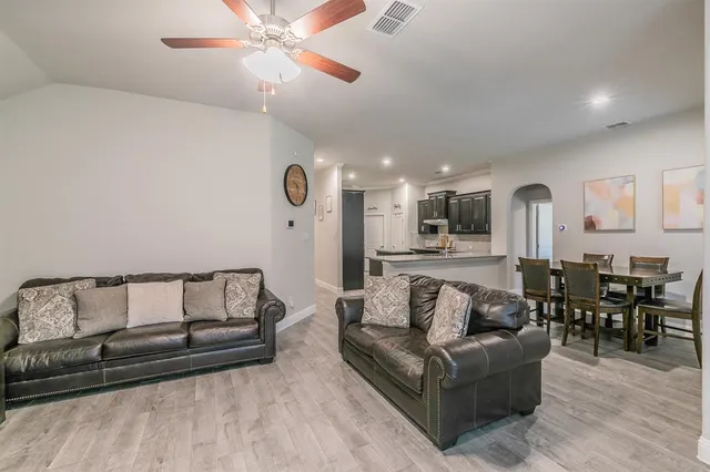 a living room with furniture and view of kitchen