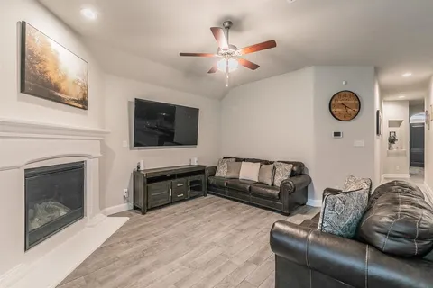 a living room with furniture a flat screen tv and a fireplace