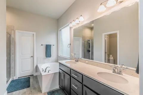 a bathroom with a granite countertop sink mirror and bathtub
